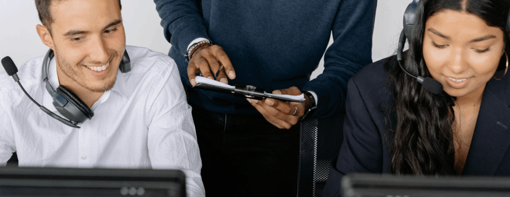 Two people discussing IT systems and support options at a desk.